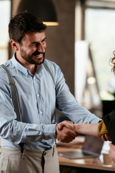 Colleagues in office. Businesswoman and businessman handshake in office..